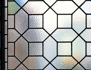 Bleiglasfenster putzen – darauf ist zu achten: Bleiverglasung mit bunten Glasstücken und Bleiruten