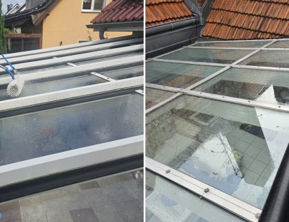 Fenster im Wintergarten putzen lassen: Reinigungsbürsten mit Wasser und Teleskopstange auf Wintergartendach